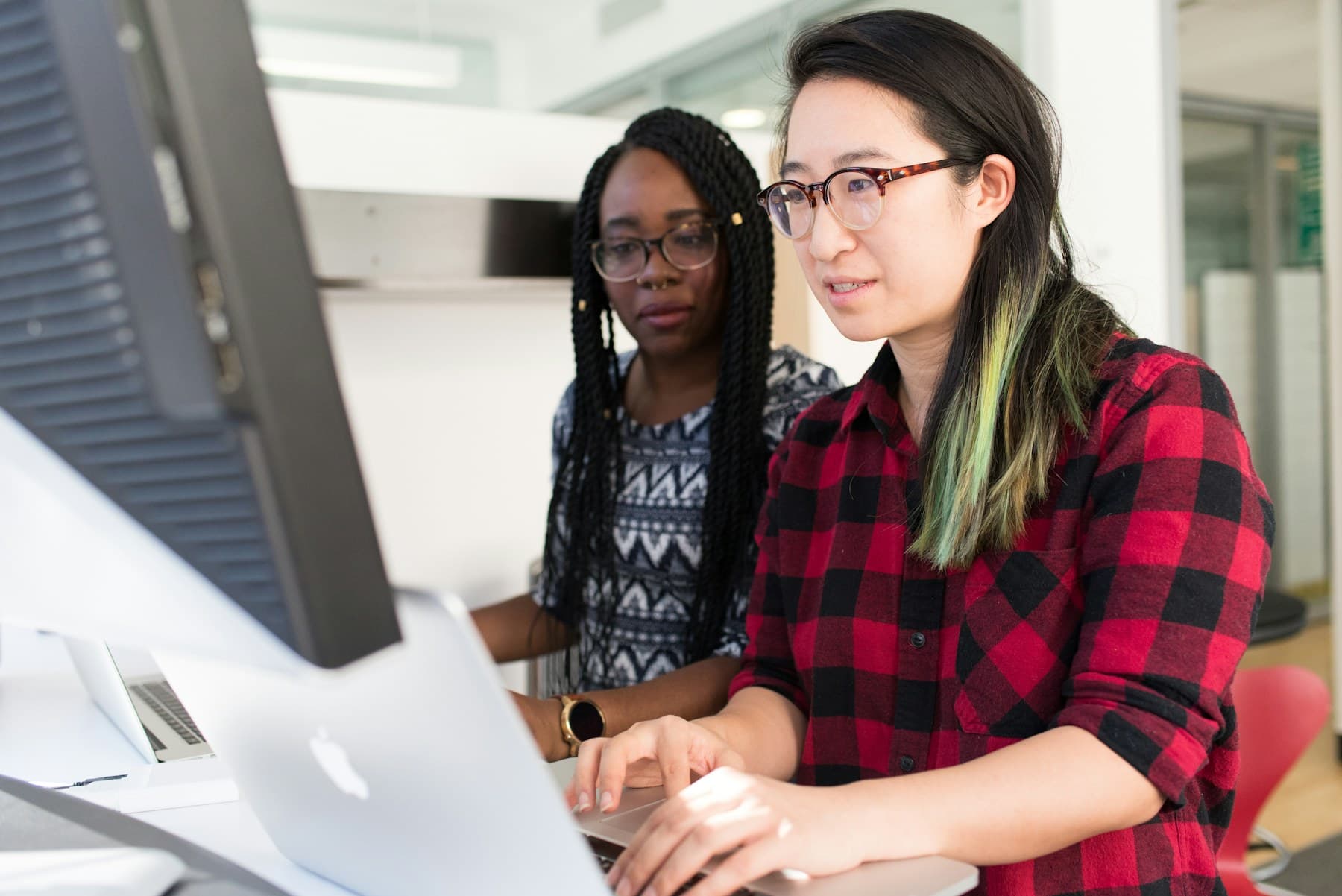 Two software professionals collaborating at a workstation
