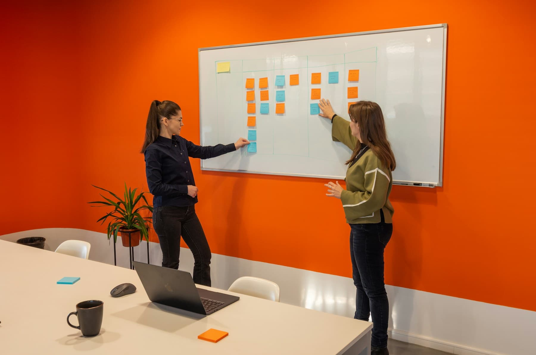 Two colleagues mapping work on a whiteboard